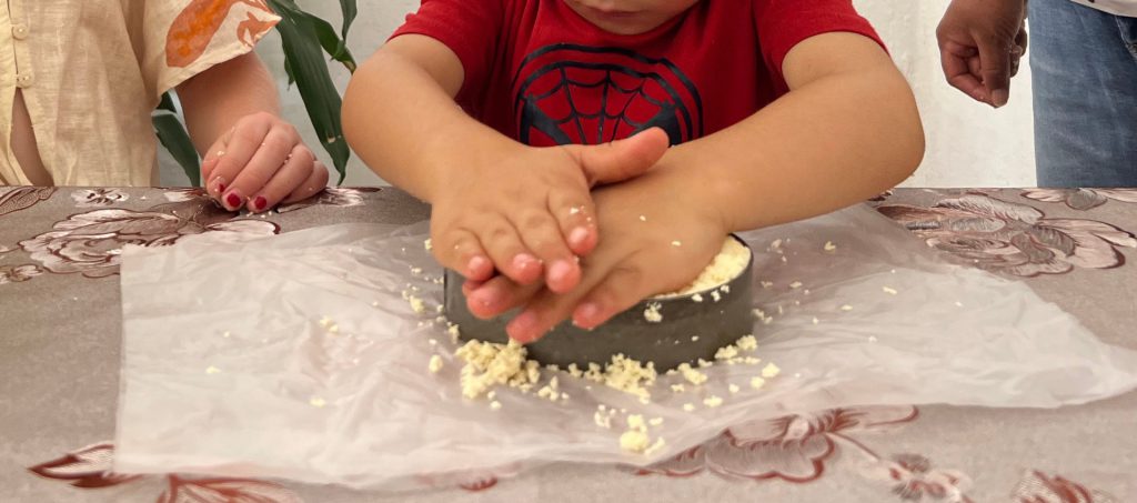 Proceso de ordeña manual y elaboración de quesos frescos en un taller para niños.